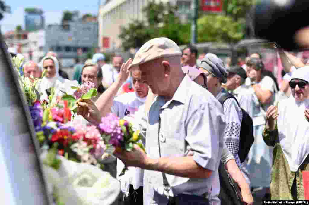 People line the streets in Sarajevo on July 9 to honor the recently identified remains of 14 victims of the massacre who are making one final trip before being interred at the Potacari Memorial Center. More than 6,750 of the estimated 8,300 victims have been laid to rest at Potacari. &nbsp;