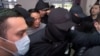 Surrounded by security officers, Raimbek Matraimov appears at a courthouse in Bishkek on March 27. 