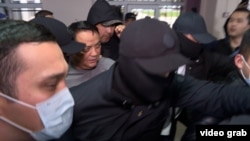 Surrounded by security officers, Raimbek Matraimov appears at a courthouse in Bishkek on March 27. 