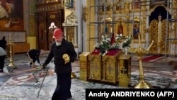 Pravoslavni svećenik skuplja sakralne predmete unutar crkve Svetog Pokrova, oštećene projektilima u Zaporižju 18. oktobra.