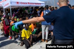 Migranți așteaptă să fie transferați de pe insula Lampedusa, Italia, 15 septembrie 2023. Albania a acceptat să găzduiască pe teritoriul său două centre de procesare a migranților care vor fi gestionate de Italia.