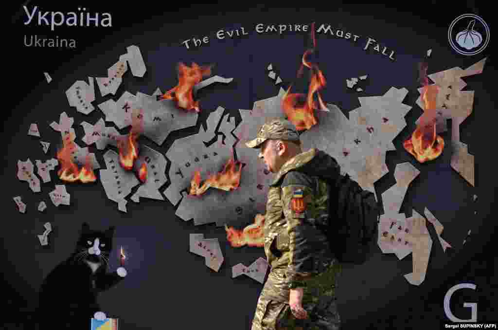 Vojnik prolazi pored transparenta koji prikazuje Rusiju u plamenu s natpisom &quot;Imperija zla mora pasti&quot; u centru Kijeva usred ruske invazije na Ukrajinu, 26. oktobra.