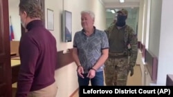 Robert Shonov is escorted by officers to the courtroom at the Lefortovo district court in Moscow in May.