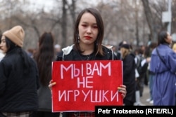 Участница митинга держит плакат «Мы вам не игрушки». Алматы, 8 марта 2023 года