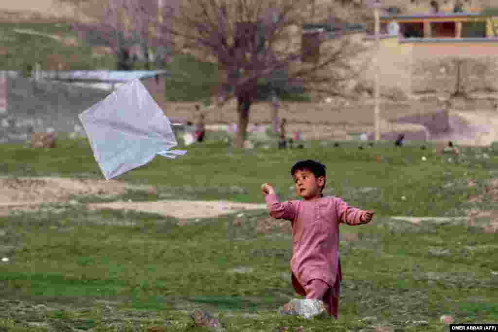 A boy flies a kite in a field in the Fayzabad district of Badakhshan Province.