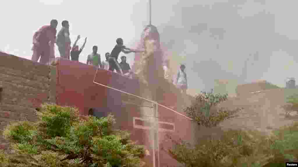 Protesters stand on the roof of a church in Jaranwala&nbsp;as they vandalize the building.