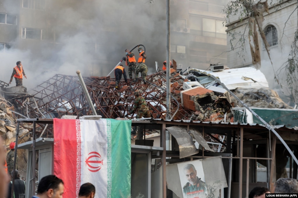 Emergency and security personnel extinguish a fire at the site of a suspected Israeli air strike against the Iranian Consulate in Syria's capital, Damascus, on April 1.