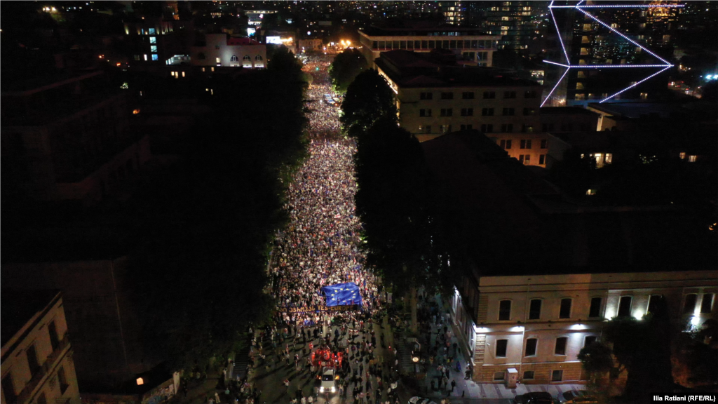 Această imagine preluată dintr-o înregistrare video arată mii de georgieni care au protestat până târziu în noaptea de 28 spre 29 aprilie, cerând guvernului să retragă controversatul proiect de lege privind &bdquo;agenții străini&rdquo;.