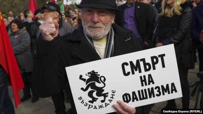 Yolo Denev, who ran for president of Bulgaria in 2021, holds a sign vowing “Death to Fascism” during the protest. Bulgaria’s acting Prime Minister Galab Donev said any government action on the monument should be taken after the upcoming parliamentary elections on April 2 “so the proper decision can be made in a calm environment.”