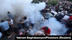 ARMENIA - Demonstrators react to stun grenades fired by law enforcement officers during a protest against Armenian Prime Minister Nikol Pashinian in Yerevan, June 12, 2024. 