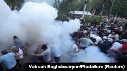 ARMENIA - Demonstrators react to stun grenades fired by law enforcement officers during a protest against Armenian Prime Minister Nikol Pashinian in Yerevan, June 12, 2024.