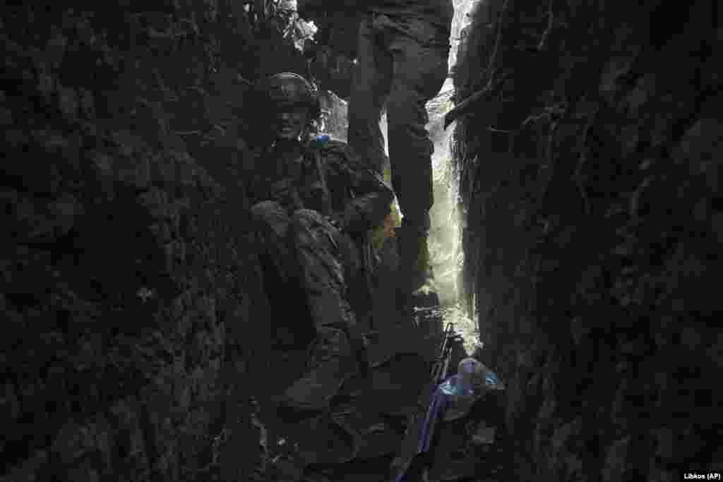 As the shelling continues, a Ukrainian soldier hunkers down in a trench. &nbsp;