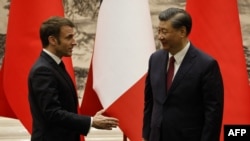 Președintele francez Emmanuel Macron îl salută pe omologul său chinez Xi Jinping, în timpul unei conferințe de presă comune la Beijing, 6 aprilie 2023.