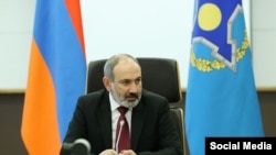 Никол Пашинян на фоне флагов Армении и ОДКБ