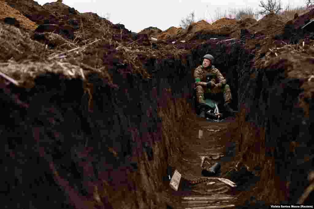 A Ukrainian soldier listens to artillery fire. Bakhmut has endured months of shelling.