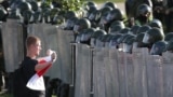 A protester faces riot police during an anti-government demonstration in Minsk in September 2020.