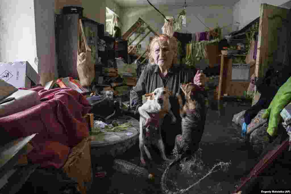 Local resident Tetyana holds her pets, Tsatsa and Chunya, above the floodwater as she stands inside her house in the Ukrainian port city of Kherson on June 6.&nbsp; &nbsp;