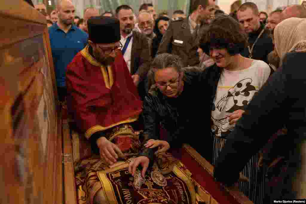 Believers touch a cross believed to have been used by Bishop Nikolai during the Feast of the Ascension. &nbsp;