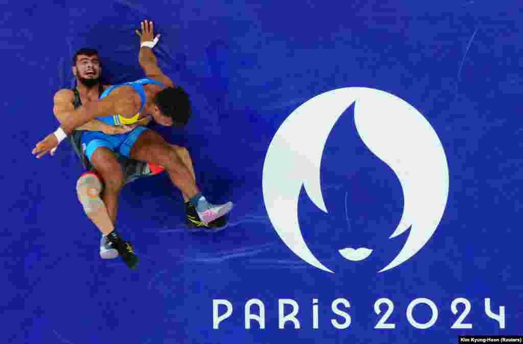 Iran&#39;s Alireza Mohmadipiani (bottom) and Ukraine&#39;s Zhan Beleniuk compete during their men&#39;s Greco-Roman 87-kilogram semifinal wrestling match on August 7. Beleniuk, the first black member of Ukraine&rsquo;s parliament, won a bronze medal on August 8. &nbsp;