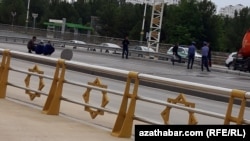 Группа людей и полицейских стоят на одной из дорог Ашхабада. Май 2024 года