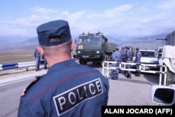 A truck of the Russian peacekeepers drives through the border from the Azerbaijani side past Armenian police forces near Kornidzor on September 22.