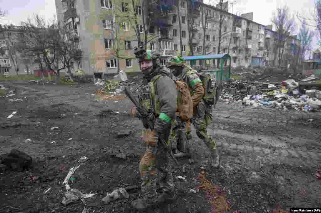 Trupe ucrainene printr-un cartier din Bahmut pe 12 aprilie.&nbsp; Soldații ucraineni spun că orașul Bahmut este atacat de &bdquo;valuri umane&rdquo; ale armatei ruse, comparabile cu tacticile folosite de Armata Roșie sovietică în timpul celui de-al Doilea Război Mondial, care duceau multe pierderi umane.