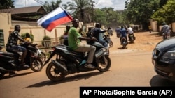 Orosz zászlót tart egy motoros Burkina Fasóban. A kép jól mutatja Moszkva befolyását az országban az Afrika Hadtesten, az újjáalakult Wagner-csoporton keresztül (archív fotó)