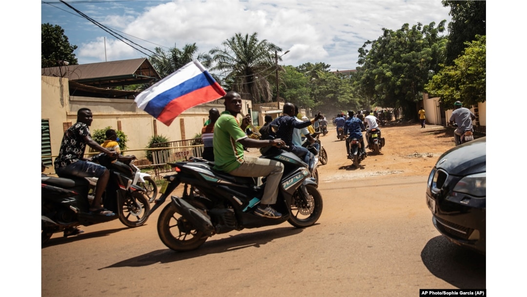Suporterii căpitanului Ibrahim Traore cu un steag rusesc pe străzile orașului Ouagadougou, Burkina Faso, la 2 octombrie 2022.