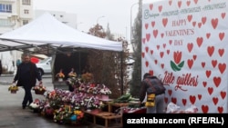 Türkmenistanda Keramatly Walentin, ýagny Söýgüliler gününe degişli plakatyň öňünde gül satýan söwda tekjeleriniň biri (Illýustrasiýa suraty)