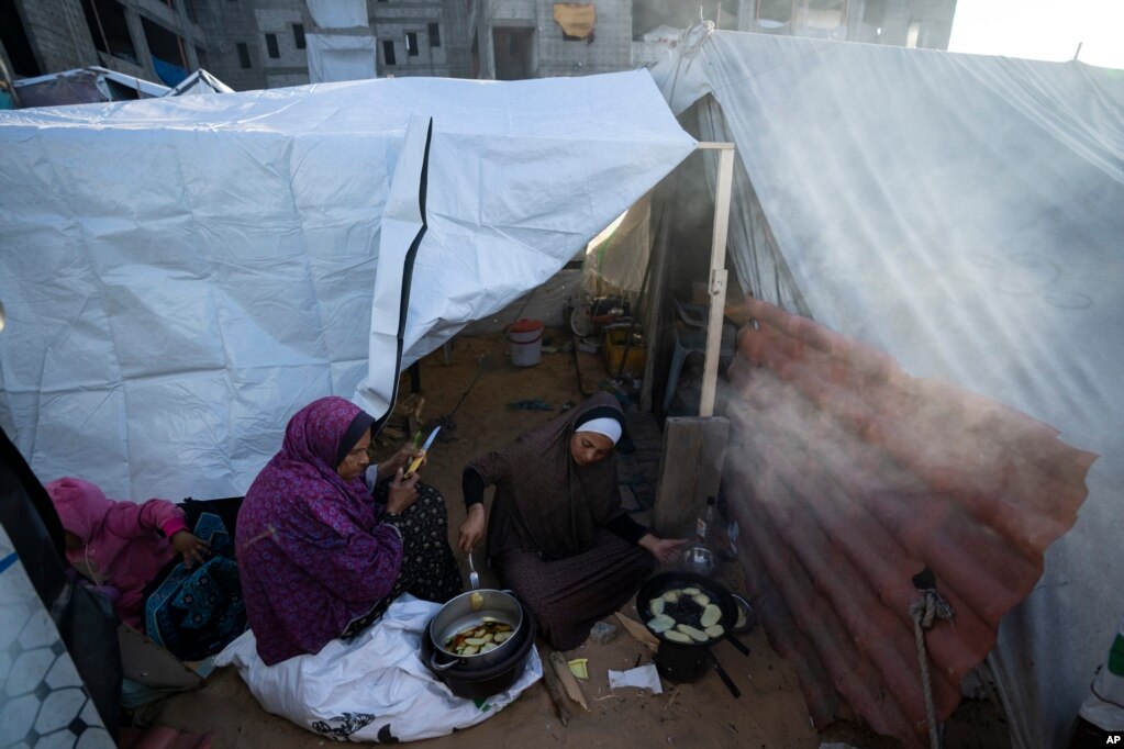 Randa Baker (desno) s majkom priprema iftarski obrok u improviziranom šatorskom kampu u području Muwasi, na jugu Pojasa Gaze, 11. marta. Dok je muslimanski svijet dočekao ramazan uobičajenim dnevnim postom, mnogi stanovnici Gaze su se probudili zbog bombardiranja koje je dovelo do toga da stanovnici još jednom traže preživjele i tijela u ruševinama uništenih domova.