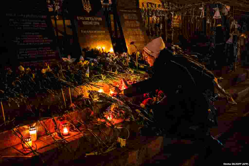 A woman lights a candle in Kyiv to pays tribute to the Maidan activists, also called the &quot;Heroes of the Heavenly Hundred,&quot; in reference to the participants killed during anti-government protests in 2014.