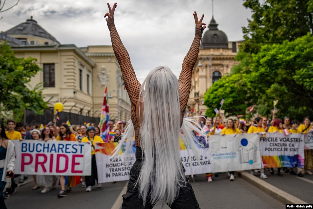 Një pjesëmarrës formon shenjën e fitores gjatë paradës së krenarisë në Bukuresht, Rumani, më 29 korrik 2023. Sipas organizatorëve dhe mediave lokale, parada e krenarisë ishte më e madhja deri më tani në kryeqytetin rumun me më shumë se njëzet mijë pjesëmarrës që bënin thirrje për të drejta ligjore për homoseksualët, si bashkësitë e regjistruara civile, martesa ose e drejta për të birësuar një fëmijë.