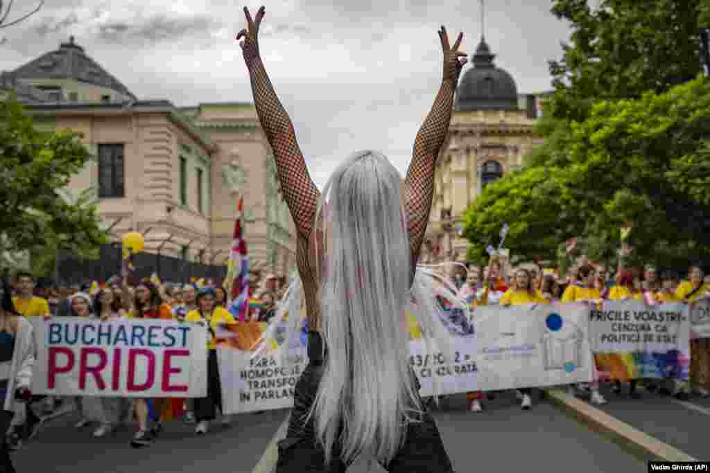 Un participant arată semnul victoriei în timpul unei parade a comunității LGBT din București, România, 29 iulie 2023. Potrivit organizatorilor și presei locale, parada a fost cea mai mare de până acum în capitala României, cu peste douăzeci de mii de participanți care au cerut drepturi legale pentru homosexuali persoane, cum ar fi parteneriatul civil, căsătoria sau dreptul de a adopta un copil. (AP Photo/Vadim Ghirda)