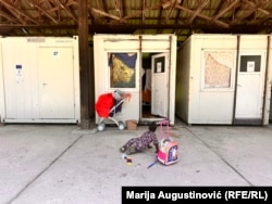 Djevojčica se igra ispred kontejnera u kampu "Ušivak", 18. juni 2024.