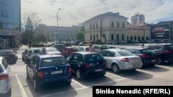 Parking koji je odlukom Ustavnog suda BiH pripao preduzeću "Autoprevoz", sa zgradom banjalučke Gradske uprave (sredina) i Muzejem savremene umjetnosti RS (desno), Banja Luka, BiH, 12. april 2023.