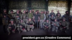 Ukrainian President Volodymyr Zelenskiy (center), during a trip to the Donetsk region, poses for a photo with Ukrainian troops in an image released on June 26.