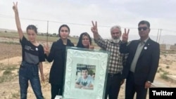 Abolfazl Adinezadeh's family hold a picture of the young man, who was killed during protests in Iran in October 2022. (file photo)