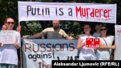Disa protestues duke mbajtur në dorë banerë me mbishkrimin: "Putini është vrasës", në Podgoricë, më 20 gusht 2023.