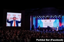 Лидер партии «Шор» Илан Шор (на экране) приветствует Евгению Гуцул, вступившую в должность главы Гагаузии, 19 июля 2023 года