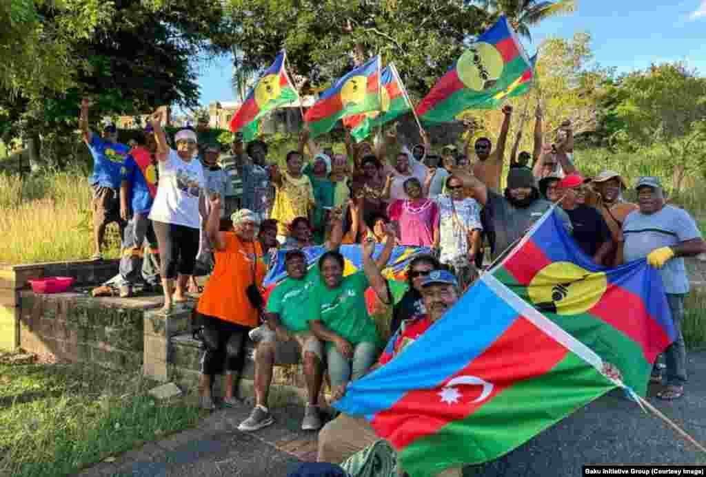 A group of protesters in New Caledonia hold Kanak and (bottom right) the Azerbaijani flag. Azerbaijani President Aliyev has said his interest in France&#39;s overseas territories lies in helping indigenous people &quot;to organize and conduct systematic and consistent efforts to eradicate [colonialism].&quot; &nbsp;