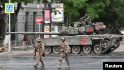 Combatanți din grupul de mercenari Wagner patrulează o stradă în apropierea sediului Districtului Militar de Sud din orașul Rostov-on-Don, Rusia, pe 24 iunie.