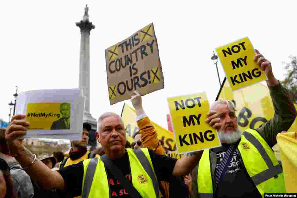 Tüntetők &bdquo;Nem az én királyom&rdquo; és &bdquo;Ez a mi országunk!&rdquo; feliratú plakátokat tartanak a Trafalgar téren, közel a Westminster-apátsághoz, a koronázás helyszínéhez