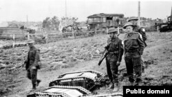 Британські військові стоять на фоні захоплених німецьких наземних дронів-камікадзе «Голіят», Франція, битва за Нормандію, 1944 рік