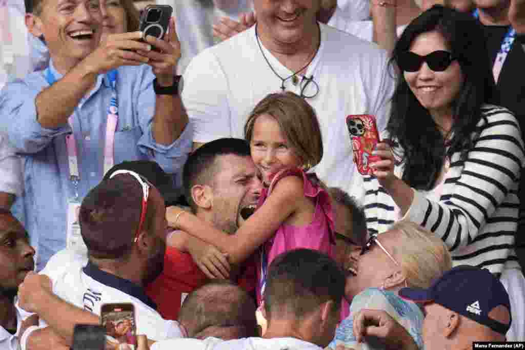 Novak Djokovic of Serbia embraces his daughter Tara after defeating Spain&#39;s Carlos Alcaraz in the men&#39;s singles tennis final on August 4. Djokovic said winning the gold was the &quot;biggest success [of his] career&quot; and promised to donate the $210,000 earnings awarded by the Serbian government to Serbian charities.