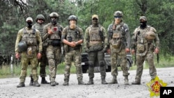 In a photo released by Belarus's Defense Ministry on July 20, Belarusian special forces and mercenaries pose during maneuvers near the border city of Brest. 