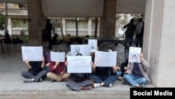 A group of young women students at Tehran University's fine arts faculty hold a protest last month.