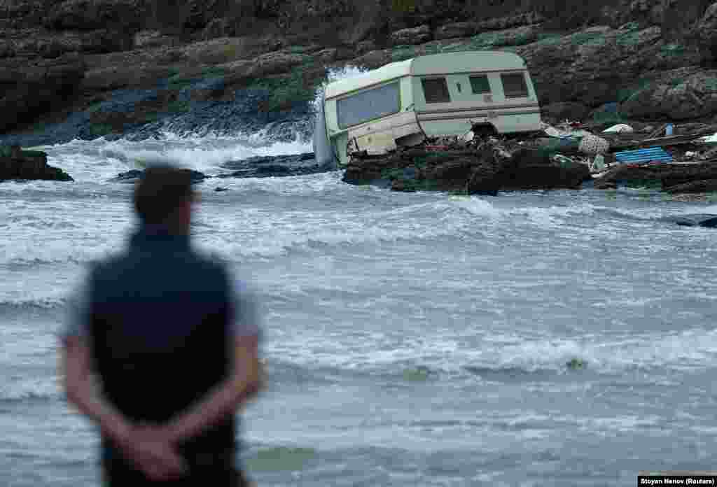 A man looks at a damaged caravan that was washed away by severe flooding. The missing mother and child were last seen in their car when the damaged bridge they were attempting to cross was swept out into the sea. &nbsp;