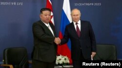 Președintele rus Vladimir Putin (dreapta) și liderul nord-coreean Kim Jong Un (stânga) își strâng mâinile la cosmodromul Vostohnîi din regiunea Amur, pe 13 septembrie 2023, înainte de discuțiile planificate care ar putea duce la un acord de armament.