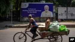 Plakat sa likom indijskog premijera Narendre Modija i porukom "Fokus na isceljenju, harmoniji i nadi za svet" na ulici u Nju Delhiju pred samit G20 u prestonici Indije, 7. septembra 2023.