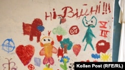 Children's drawings provide a splash of color on the kindergarten basement wall in Yahidne. The words read "No to war!!!"